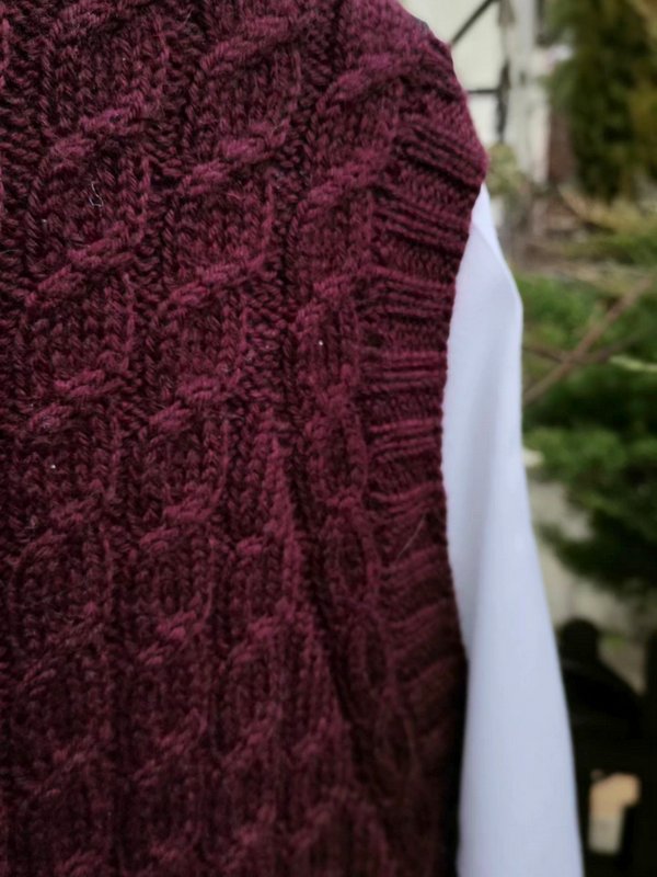 Zbliżenie na dzierganą kamizelkę w warkocze