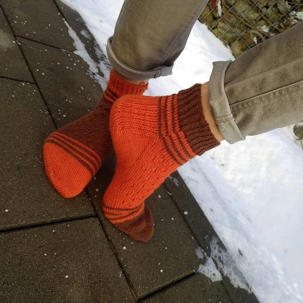 krufka socks na drutach pomaranczowo brazowe na stopach na tle sniegu